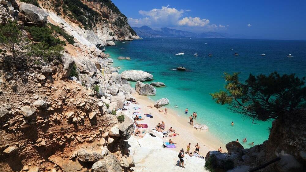 Cala Goloritzé Beach on the Italian island of Sardinia (Photo: Tupungato/Shutterstock) תיירים מבלים בחוף קאלה גולוריצה (Cala Goloritzé) שבאזור באוניי (Baunei), במחוז אוליאסטרה שבאי סרדיניה