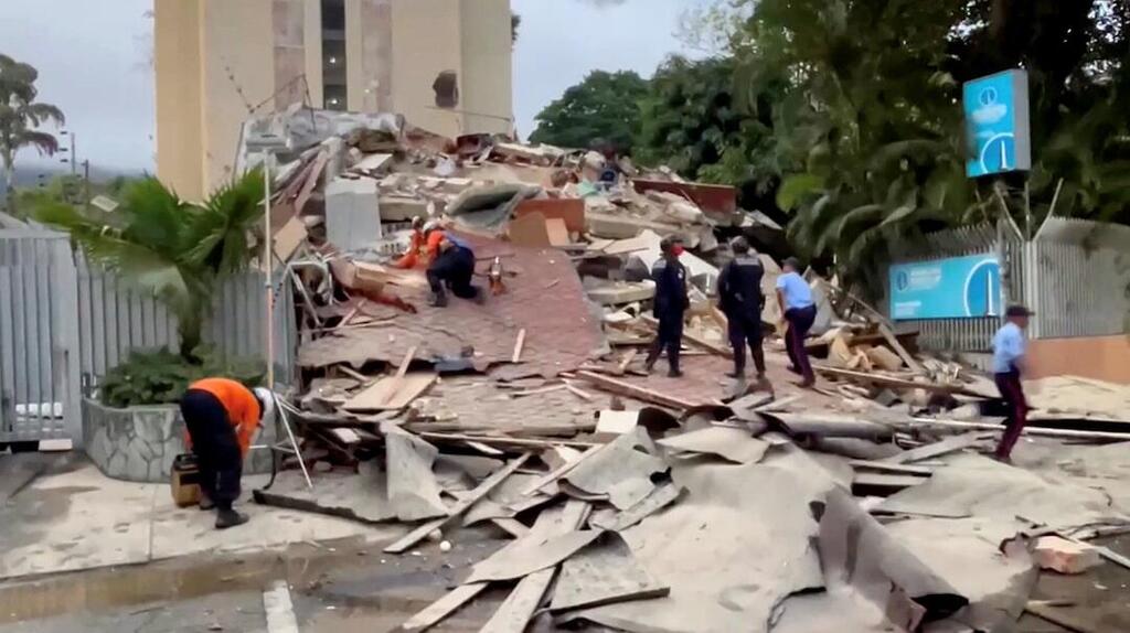 Emergency services work at the site of a collapsed building after a strong earthquake shook north-central Venezuela