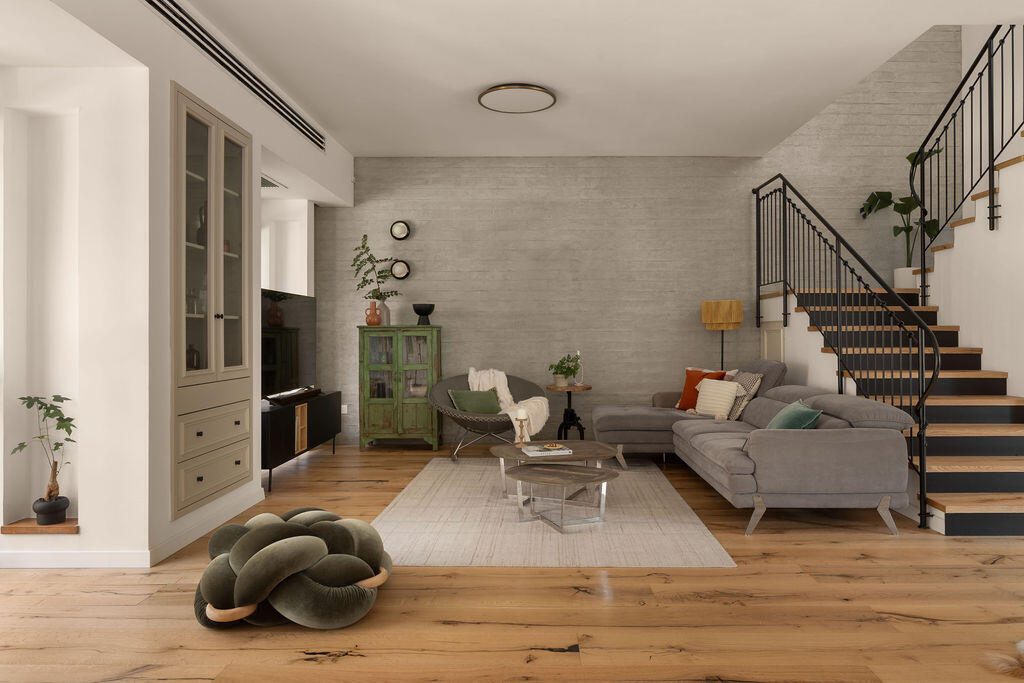 The living room, where wood parquet meets a concrete wall (Photo: Maya Avgar) בית בקדימה, עיצוב: אוסי כץ