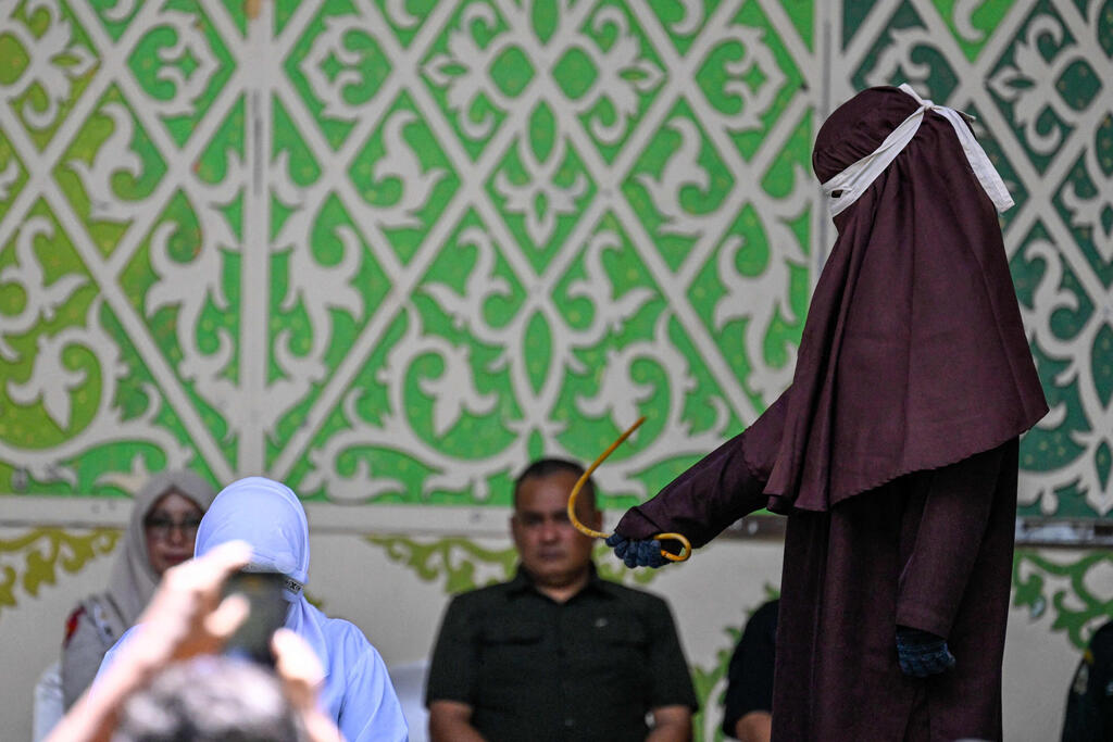 Photo: CHAIDEER MAHYUDDIN / AFP הלקאה פומבית ב אינדונזיה
