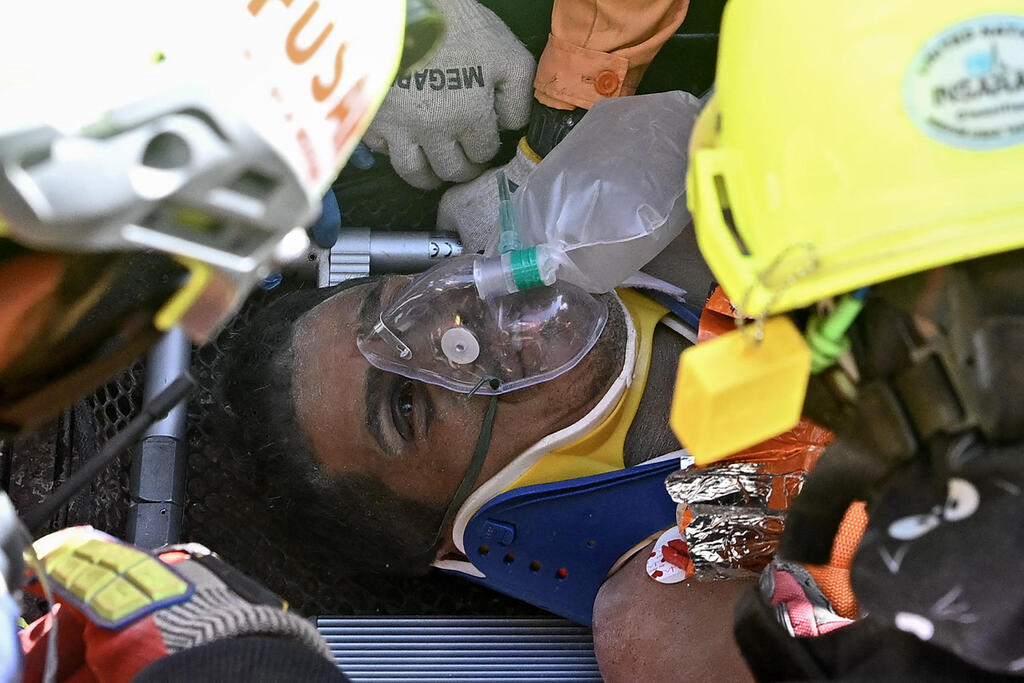 Security guard rescued from La Guaira rubble after eight days (Photo: Federico PARRA / AFP) הרנן גיל מאבטח ששרד שמונה ימים מתחת להריסות ב ונצואלה רעידת אדמה ב קאטיה לה מאר שבאזור האסון לה גואיירה 2 ביולי