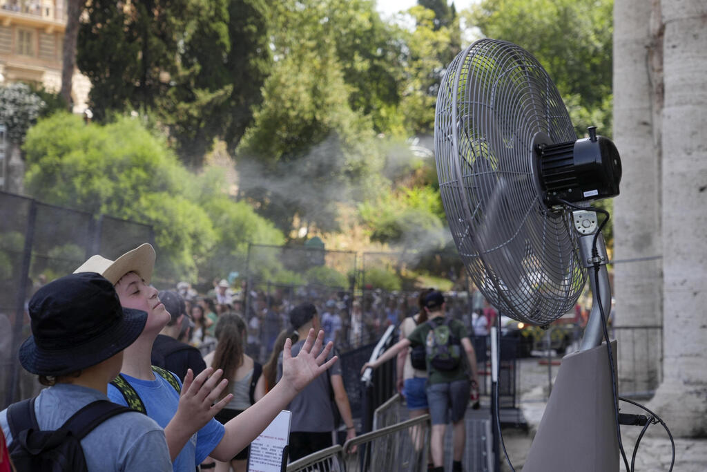 Tourists cool off during the heavy heat in Rome (Photo: Gregorio Borgia/AP) תיירים מצטננים מהחום הכבד ברומא