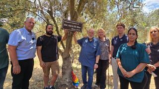 US Ambassador to Israel Mike Huckabee, center right, and former hostage Yarden Bibas, center left, stand beside a memorial olive tree dedicated to Shiri, Ariel and Kfir Bibas during a ceremony at Moshav HaYogev 