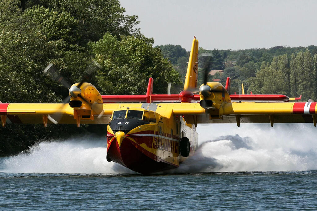 A firefighting plane takes on water from the Seine River to battle the flames in the Fontainebleau forest fire 