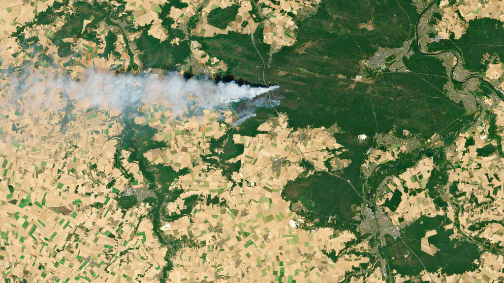Smoke rises from the forest near the UNESCO World Heritage sit (Photo: Handout / COPERNICUS SENTINEL DATA 2026 / AFP) מזג אוויר גל חום צרפת שריפה ליד פריז