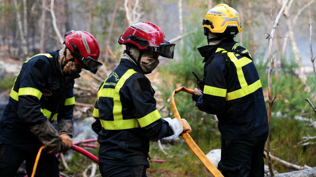 Firefighters battle the flames in France on Tuesday after 20,500 dunams burned (Photo: Dimitar DILKOFF / AFP) מזג אוויר גל חום צרפת שריפה ליד פריז