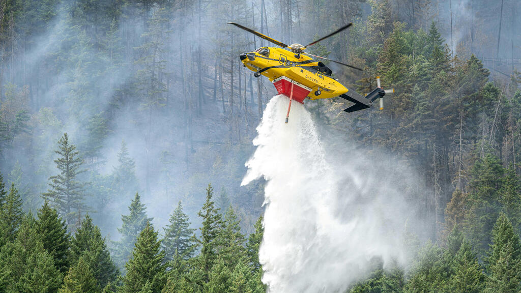 Firefighting helicopter in action in Canadian forest (Photo: BC Wildfire/Handout via Reuters) קנדה שריפות שריפה