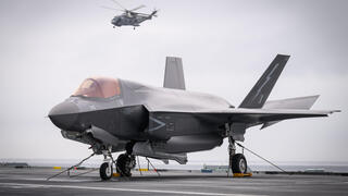 25 ביוני צבא בריטניה מסוק Merlin HM2 טס מעל מטוס קרב F-35B (דגם נחיתה והמראה אנכית של F-35 ) על גבי נושאת המטוסים הבריטית HMS Prince of Wales  במהלך תרגיל נאט"ו בים ליד נורבגיה 
