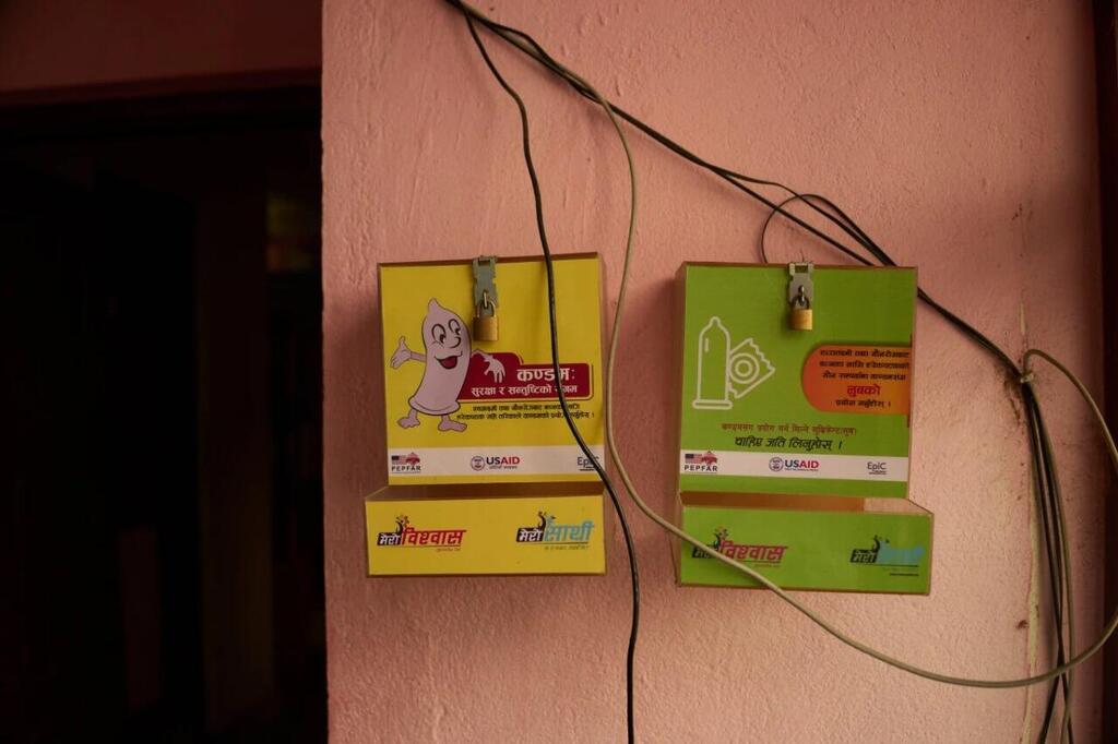 An empty condom dispenser hangs outside the USAID office in Kathmandu, the capital of Nepal (Photo: AP Photo/Bram Janssen) מתקן קונדומים ריק תלוי מחוץ למשרד בקטמנדו, נפאל