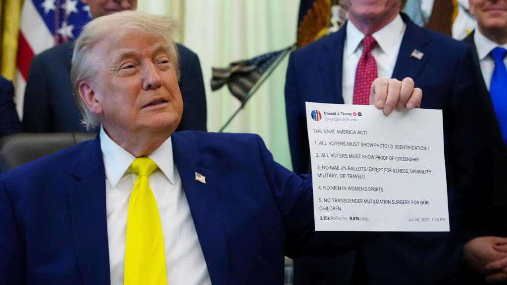  Trump shows reporters at the White House a printout of one of his Truth Social posts in June 