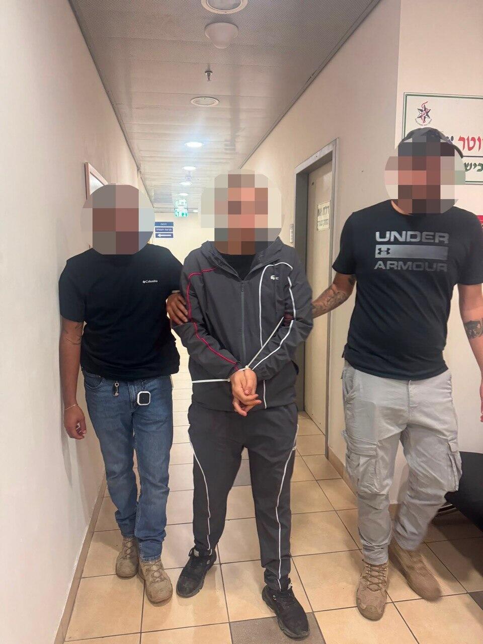 Police escort the 23-year-old suspect after he surrendered following the fatal shooting of a lawyer in an office building in Rishon Lezion (Photo: Israel Police) החשוד ברצח העורך דין בראשון לציון