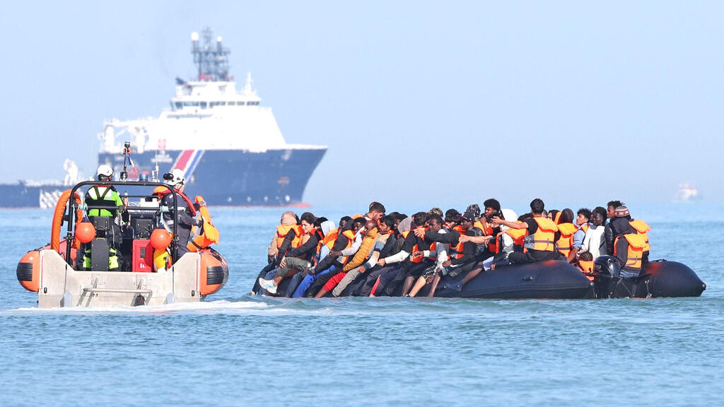 Migrants aboard a boat near the French coast in the English Channel en route to Britain, July 29 (Photo: Francois LO PRESTI / AFP) מהגרים על סירה סמוך לחופי צרפת ב תעלת למאנש בדרך ל אנגליה בריטניה 29 ביולי