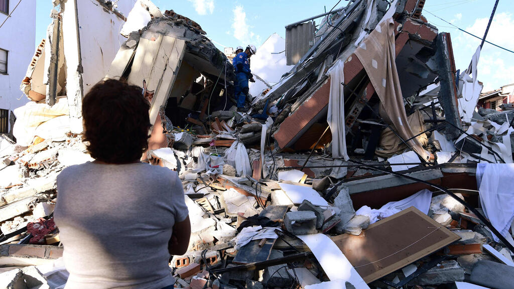 A woman waits for news of her loved ones at the site of a collapsed building (Photo: Jaime Saldarriaga/ AFP) קולומביה רעידת אדמה רעש הריסות פריירה חיפוש נעדרים