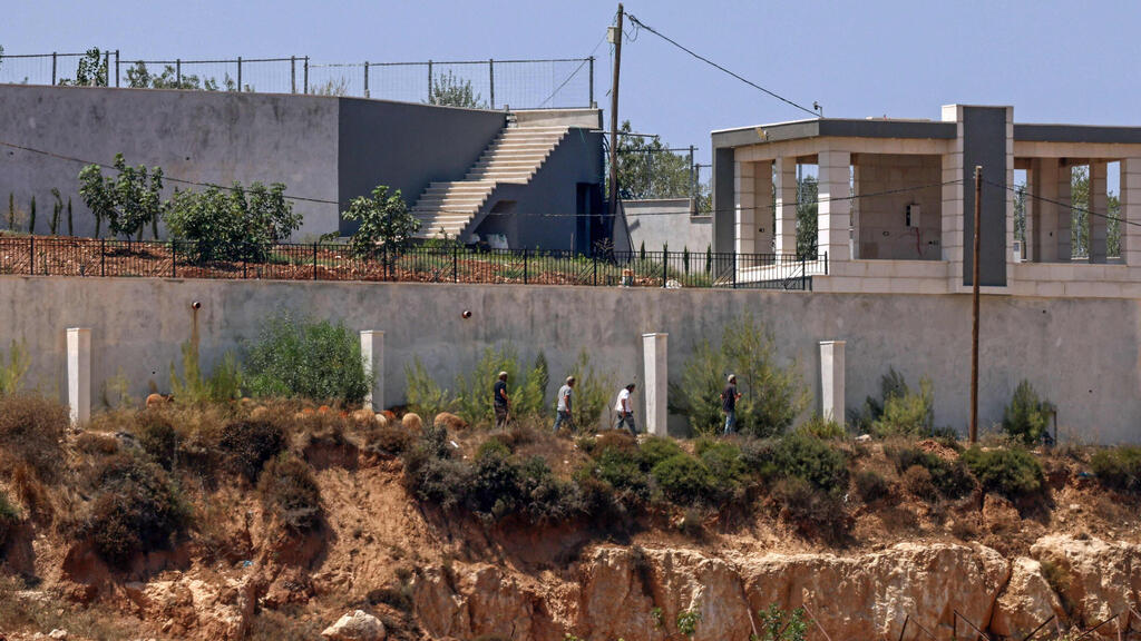 Jewish Israelis in front of Palestinian homes in the village of Qusra (Photo: Zain Jaafar/AFP) מתנחלים מול בתי פלסטינים בכפר קוסרה
