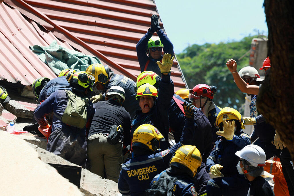 Rescuers in Cali signal for silence (Photo: Raquel Cunha/Reuters) קולומביה רעידת אדמה רעש הריסות קאלי