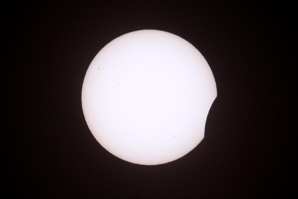 The beginning of the solar eclipse (Photo: Toby Shepheard/AFP) תחילתו של ליקוי החמה