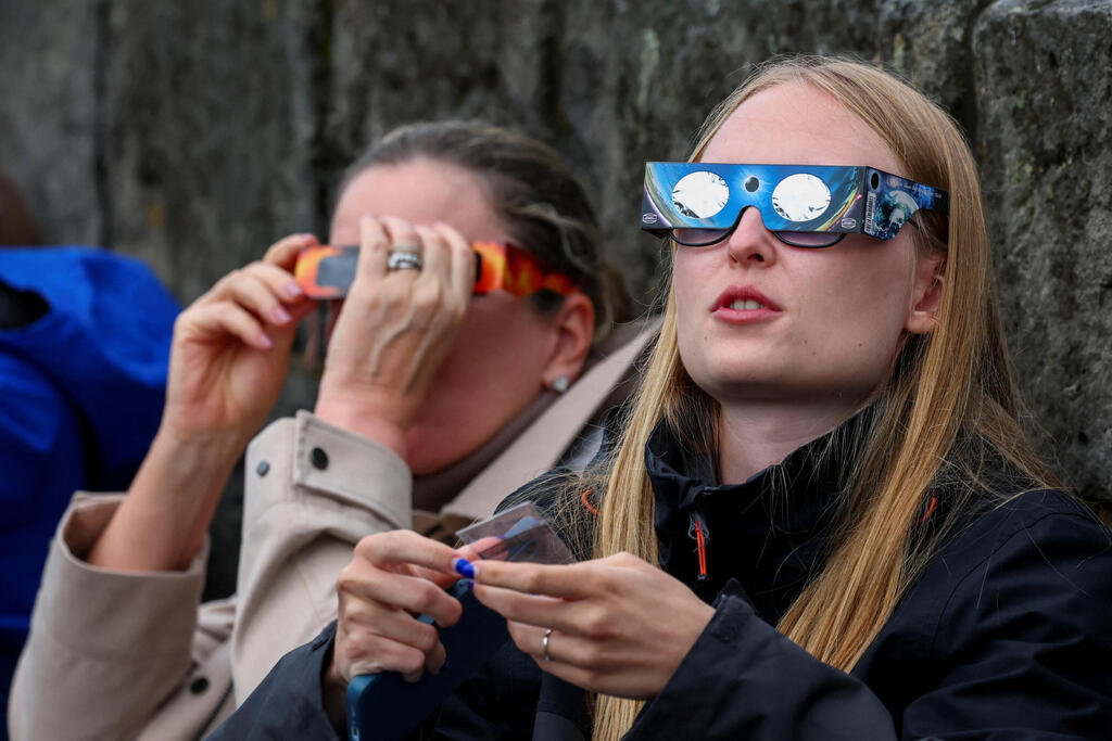 Residents of Reykjavik watch the solar eclipse (Photo: Denis Balibouse/Reuters) תושבי רייקיאוויק צופים בליקוי החמה