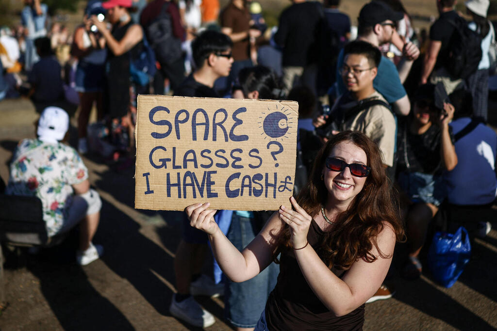 A desperate attempt to get eclipse glasses (Photo: Henry Nicholls/AFP) ניסיון נואש להשיג משקפיים לצפייה בליקוי החמה