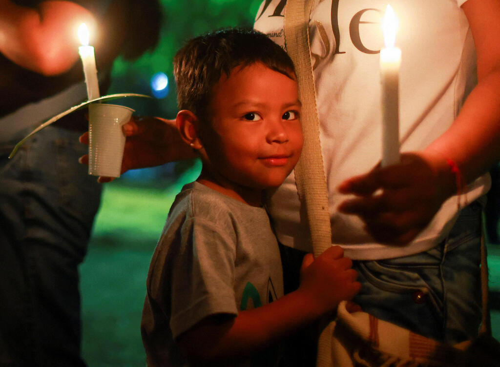 A child at a prayer and candle-lighting ceremony for earthquake victims in Cali (Photo: Raquel Cunha/Reuters) קולומביה רעידת אדמה רעש קאלי הדלקת נרות ותפילה