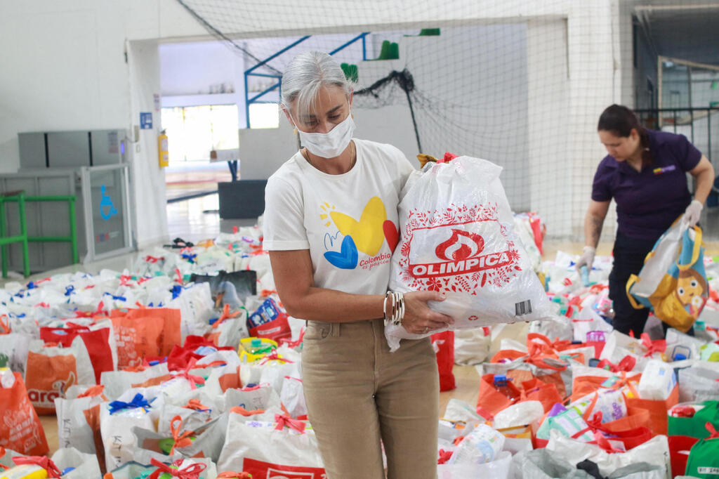 Volunteers carry bags of food for earthquake victims in Manizales (Photo: Andres Camilo Valencia/Reuters) קולומביה רעידת אדמה רעש מתנדבים סיוע אוכל מניסאלס