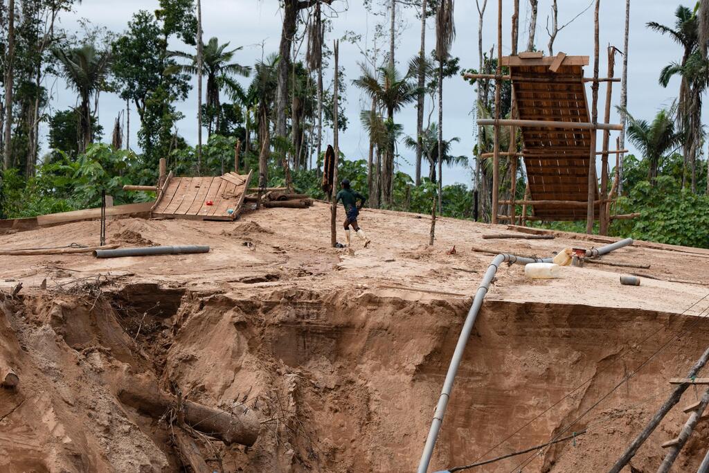 Illegal gold miner escapes from Peruvian navy forces (Photo: Guadalupe Pardo/AP) כורה זהב בלתי חוקי נמלט מכוחות חיל הים הפרואני