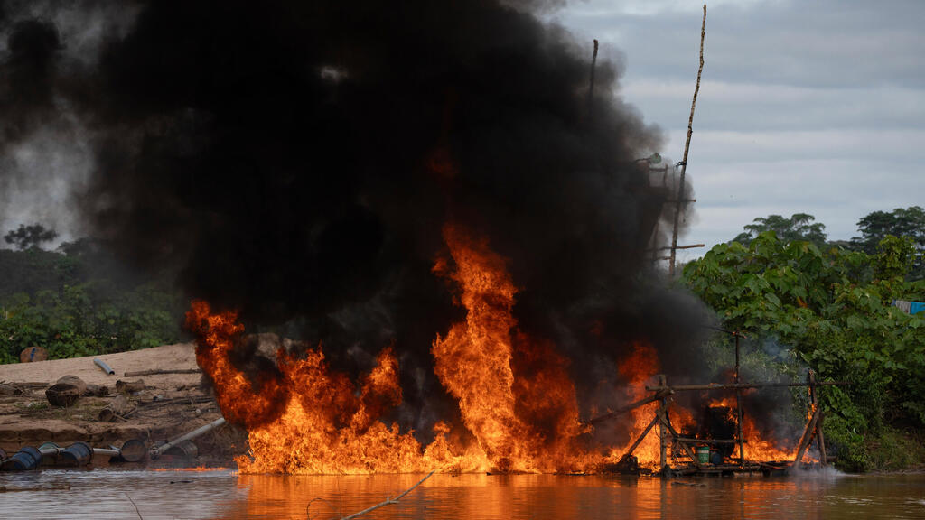 Peruvian Navy soldiers destroy equipment used by gold miners (Photo: Guadalupe Pardo/AP) השמדת ציוד ששימש את כורי הזהב על ידי חיילי חיל הים הפרואני