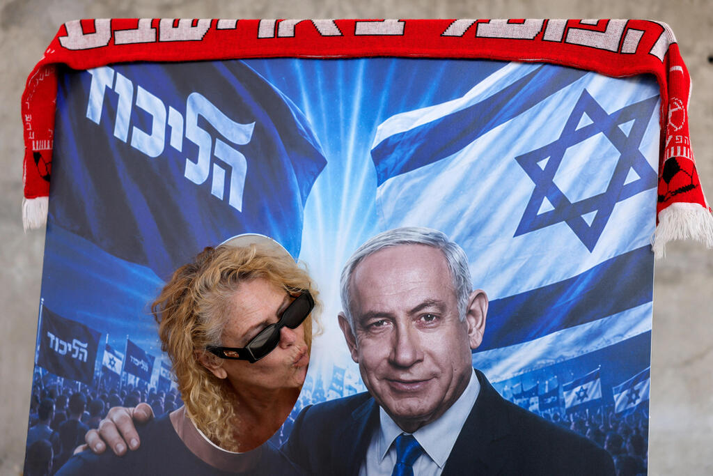 A likud supporter kisses a poster of Prime Minister Benjamin Netanyahu (Photo: REUTERS/Amir Cohen) תל אביב