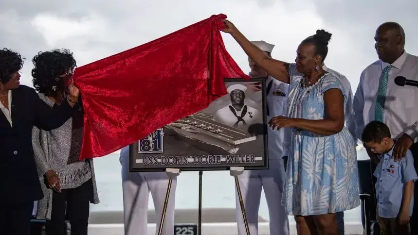 Miller's family members unveil a plaque honoring the future aircraft carrier in January 2020; it is no longer certain the ship will bear his name (Photo: Mass Communication 2nd Class Justin R. Pacheco/US Navy) בני משפחתו של דוריס מילר, גיבור מלחמה אמריקני