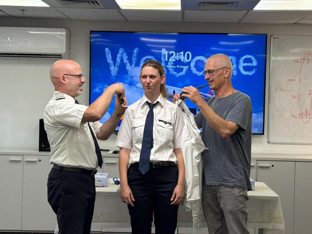 Captain Tal Madutzky and fleet manager Noam Adar present Captain Adar Madutzky with her captain’s insignia (Photo: Arkia) קברניט טל מדוצקי ומנהל הצי נועם אדר מעניקים לאדר מדוצקי את דרגות הקברניט