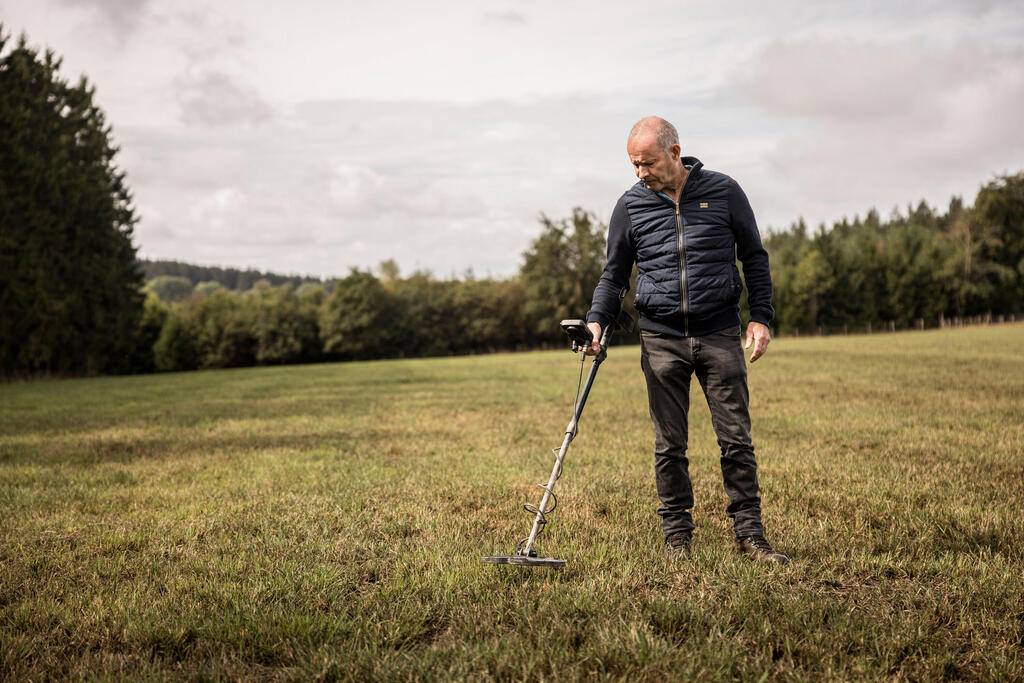 Bernard Collard with his metal detector in a field near Elsenborn, Belgium (Photo: AP Photo/Valentin Bianchi) אירופה שריפות פצצות מ מלחמת העולם השנייה ברנאר קולאר גלאי מתכות שדה באזור אלזנבורן בקרינקלט בלגיה