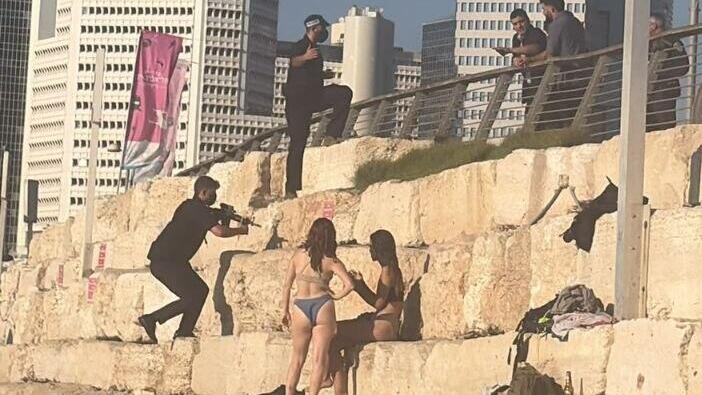 מאבטח מכוון את נשקו על מתרחצים 