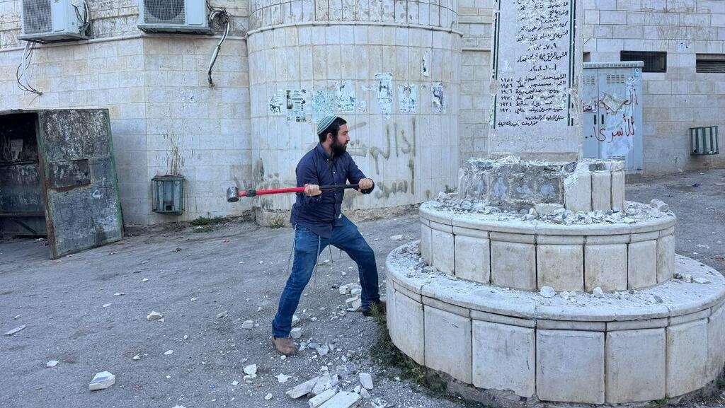 Цви Суккот крушит кувалдой памятник ח"כ צבי סוכות משחית אנדרטה לזכר השהידים בכפר מאדמה בדרום לשכם