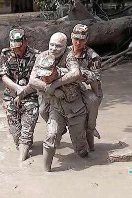 A survivor covered in mud is evacuated from a flood zone by the Nepalese army חילוץ מהצפות בנפאל
