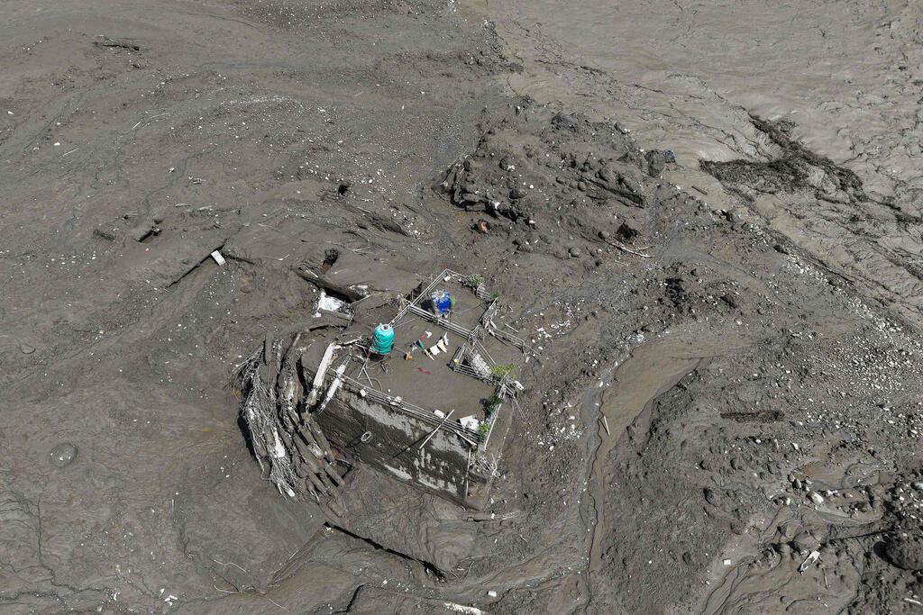 A house buried under mud carried by the landslide (Photo: Prabin RANABHAT / AFP) נפאל אסון שיטפון שיטפונות הצפות ליד גבול טיבט בית שנקבר בבוץ