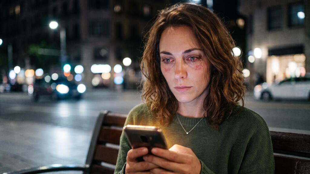 A woman with burning eyes from excessive phone use (AI illustration) אישה עם עיניים שורפות משימוש מוגזם בטלפון