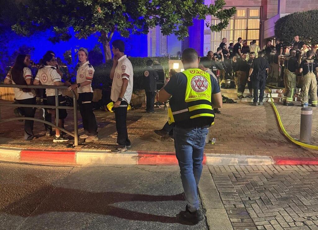 Emergency medical and rescue teams stand outside the residential building in Rishon Lezion during the response to a deadly underground garage fire (Photo: Magen David Adom) שריפה בחניון תת-קרקעי בבניין מגורים