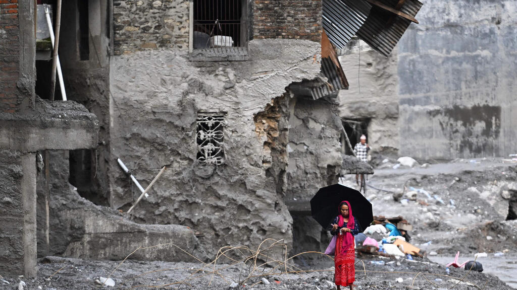 Nepalese return to their destroyed homes to search for the few valuables that may have survived (Photo: Arun Sankar / AFP) נפאל אסון שיטפון גבול טיבט מחפשים הריסות