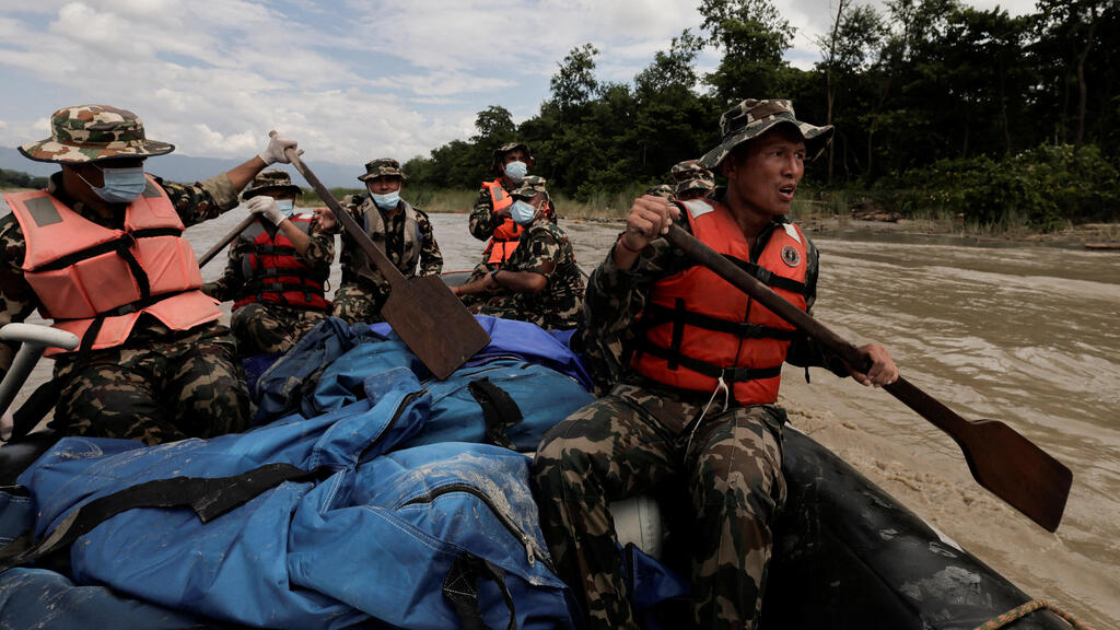 Rescue team returns to land with bodies found in Nepal river (Photo: Navesh Chitrakar/Reuters) נפאל אסון שיטפון גבול טיבט מחלצים פינוי גופות