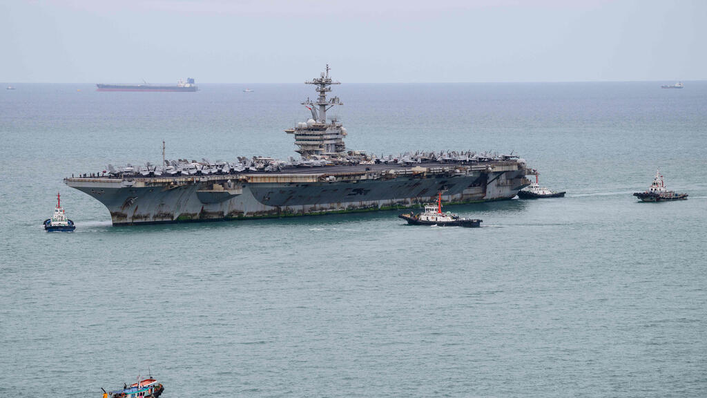 The USS Abraham Lincoln (Photo: ANTHONY WALLACE / AFP) נושאת המטוסים האמריקנית USS Abraham Lincoln בדרכה לנמל לאם צ'באנג, סמוך לפטאיה