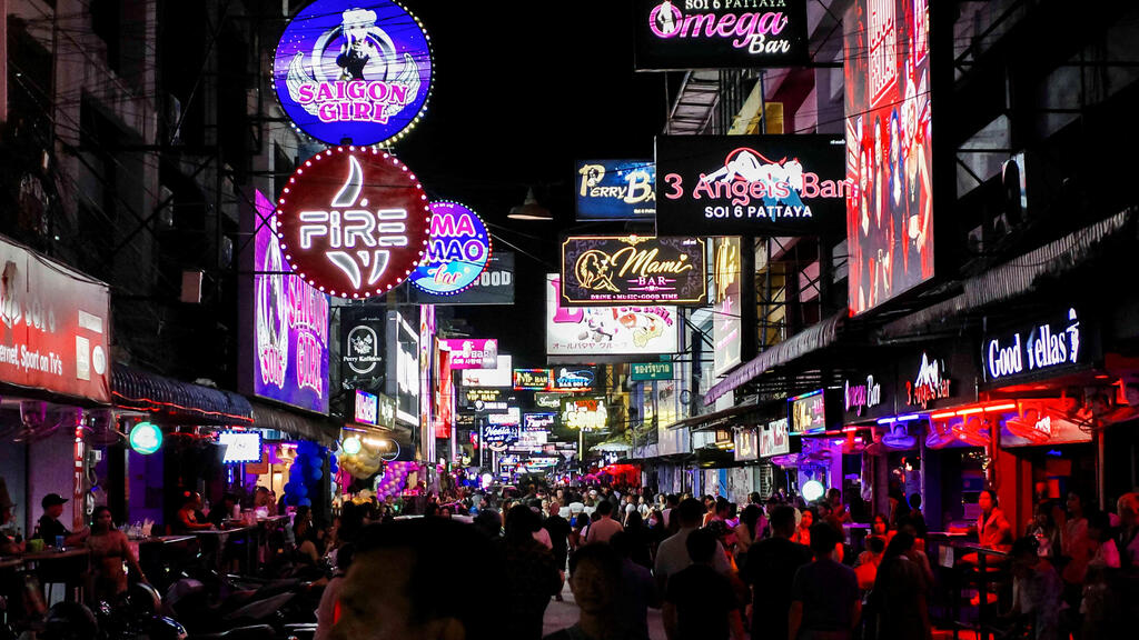 Passersby on a street lined with bars and entertainment venues in Pattaya, Thailand (Photo: REUTERS/Chalinee Thirasupa) עוברים ושבים ברחוב עמוס בברים ובמקומות בילוי בפטאיה, תאילנד