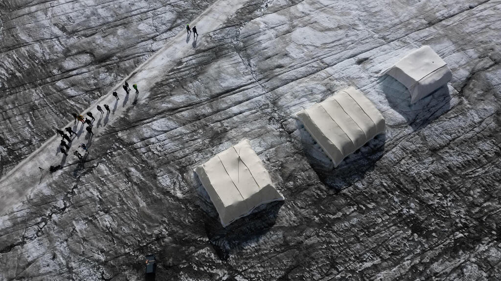 Sheep wool sheets that showed promising results in protecting Alpine glaciers (Photo: Denis Balibouse/Reuters) יריעות צמר כבשים שסיפקו תוצאות מעודדות כאמצעי הגנה על קרחונים בהרי האלפים