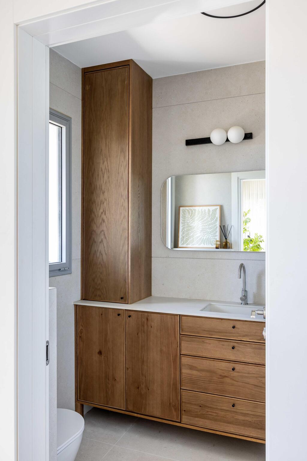 The bathroom, with wood against a light backdrop (Photo: Orit Arnon) בית דו-משפחתי ברמת גן, עיצוב: שרונה טביב