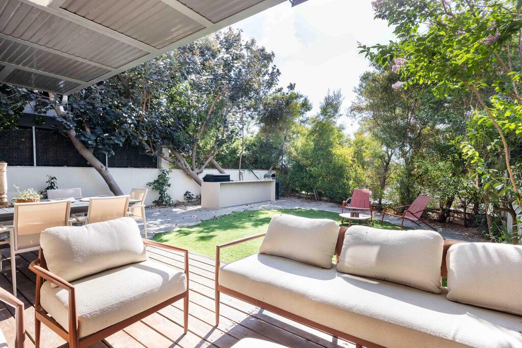 The deck, pergola, lawn and tiles were adapted to create a base for the outdoor kitchen (Photo: Orit Arnon) בית דו-משפחתי ברמת גן, עיצוב: שרונה טביב