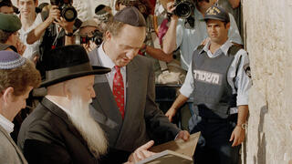 מלך ספרד חואן קרלוס (במרכז) מקבל ספר מידי הרב יהודה גץ במהלך ביקור בכותל המערבי, ב-9 בנובמבר 1993