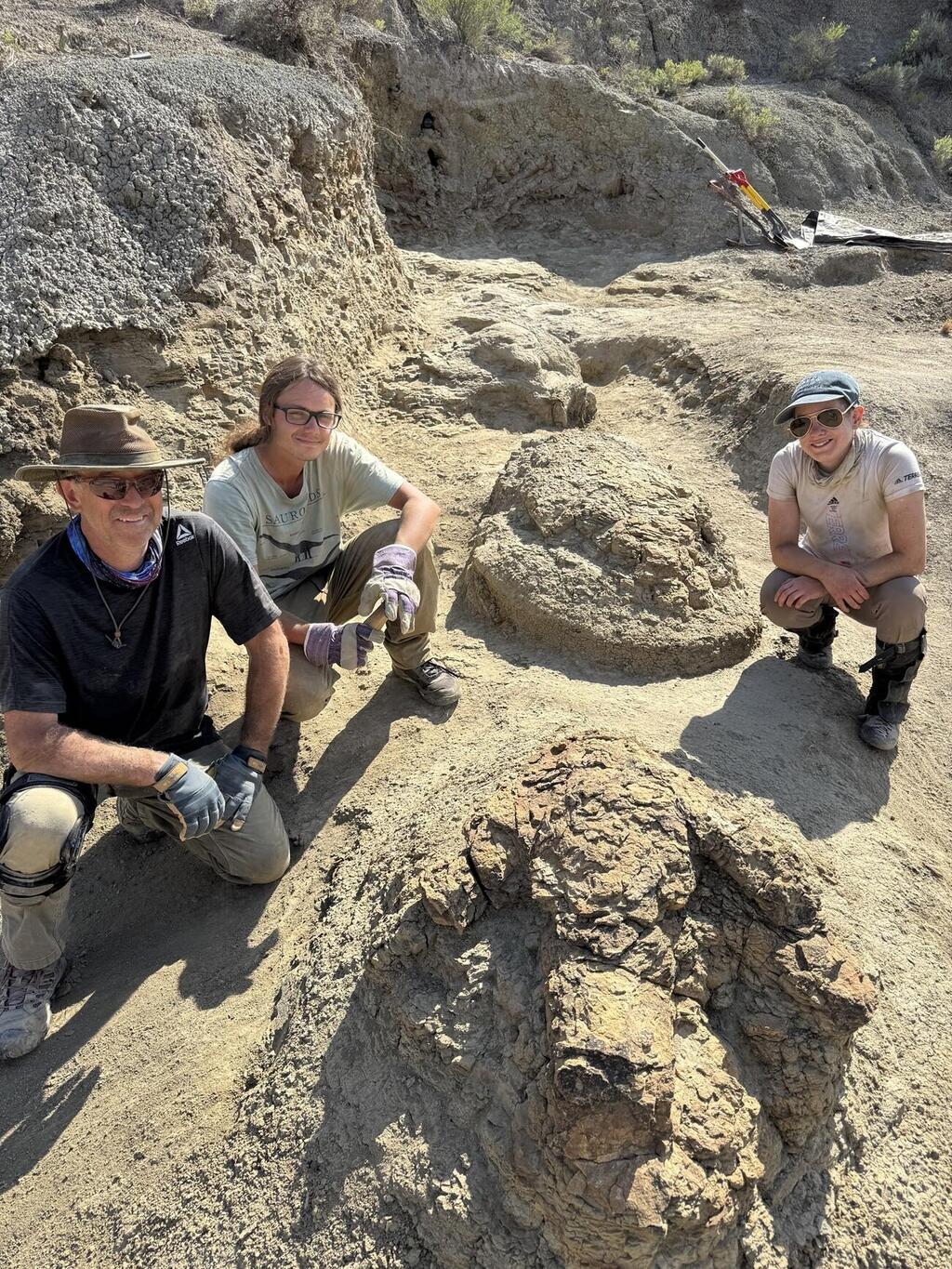 Members of the research team beside the footprints discovered in the Hell Creek Formation (Photo: Tyler Lyson/Denver Museum of Nature & Science) חברי צוות המחקר לצד העקבות שנחשפו בתצורת הל קריק
