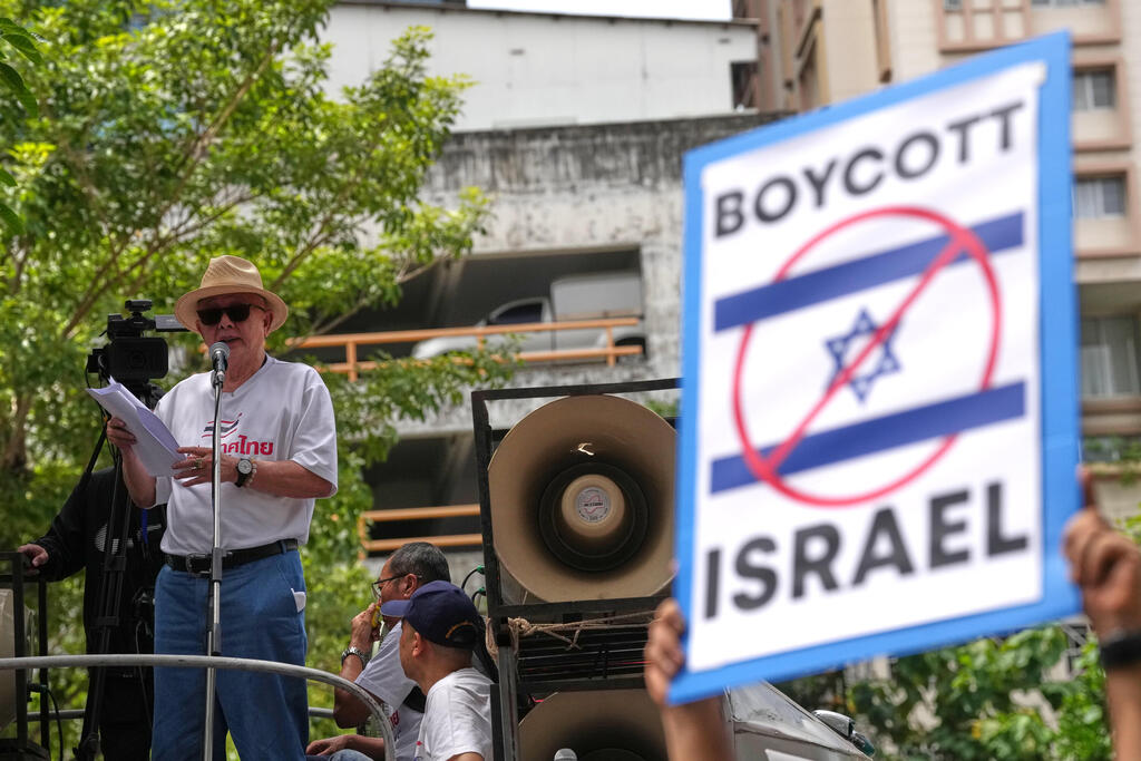 Photo: AP Photo/Sakchai Lalit סונדהי לימטונגקול, איש תקשורת ופעיל פוליטי, נואם מול תומכיו בהפגנה מול שגרירות ישראל בבנגקוק
