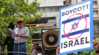 סונדהי לימטונגקול, איש תקשורת ופעיל פוליטי, נואם מול תומכיו בהפגנה מול שגרירות ישראל בבנגקוק
