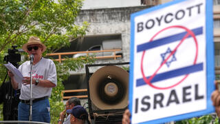 סונדהי לימטונגקול, איש תקשורת ופעיל פוליטי, נואם מול תומכיו בהפגנה מול שגרירות ישראל בבנגקוק