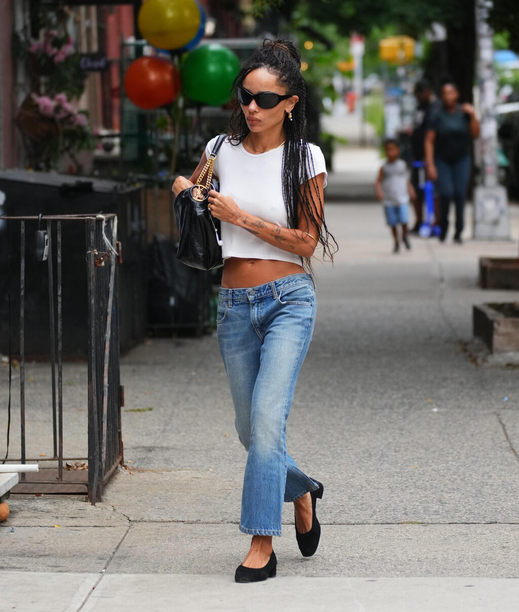 The jeans everyone will want to wear this fall (Photo: Gettyimages IL/XNYStar MaxGC) זואי קרביץ הולכת ברחוב עם ג'ינס נמוך וחולצת בטן
