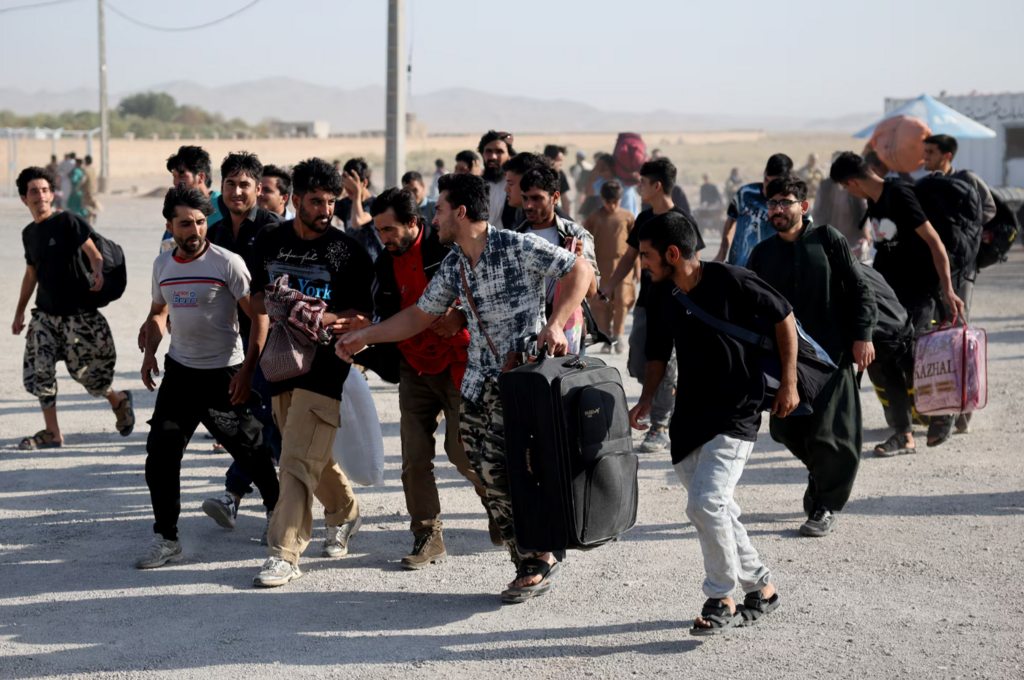 Photo: Reuters Afghan nationals carrying their belongings walk after crossing the border from Iran at the Islam Qala border crossing in Herat province, Afghanistan